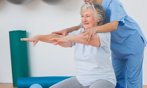 instructor que ayuda mujer mayor ejercitar